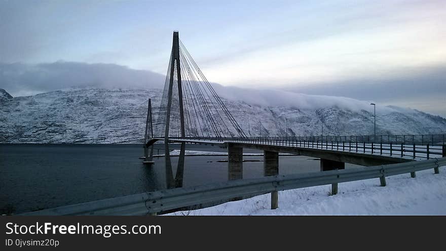 Black Suspension Bridge Under Cumulus Clouds