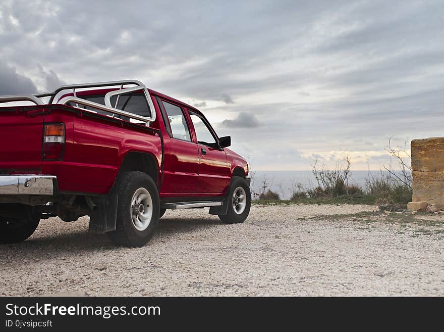 Red Pickup Truck Parked Near Wall