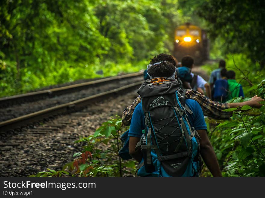 Group of People Walking Beside Train Rail