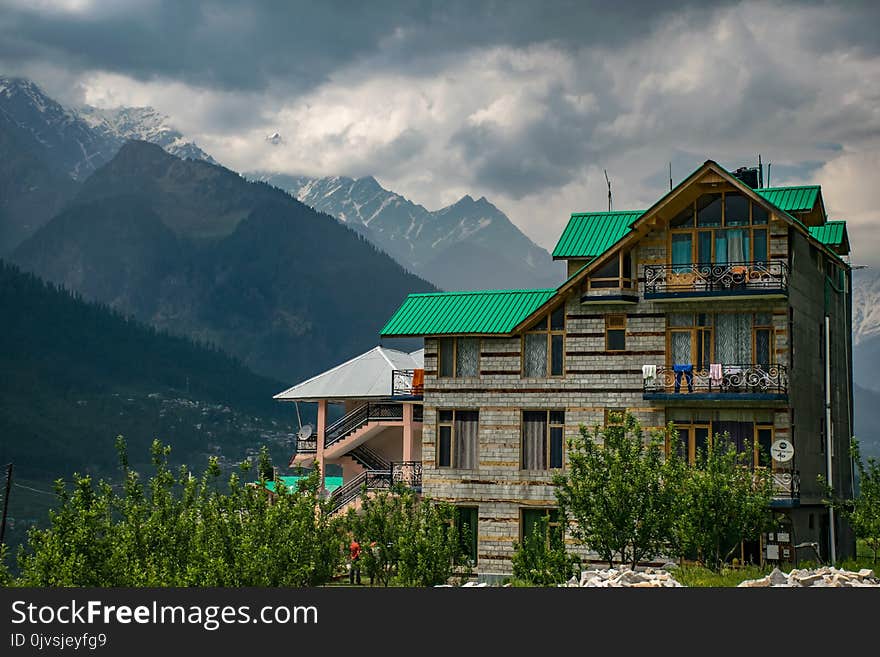 Brown and Green Concrete Building Near Mountains at Daytime