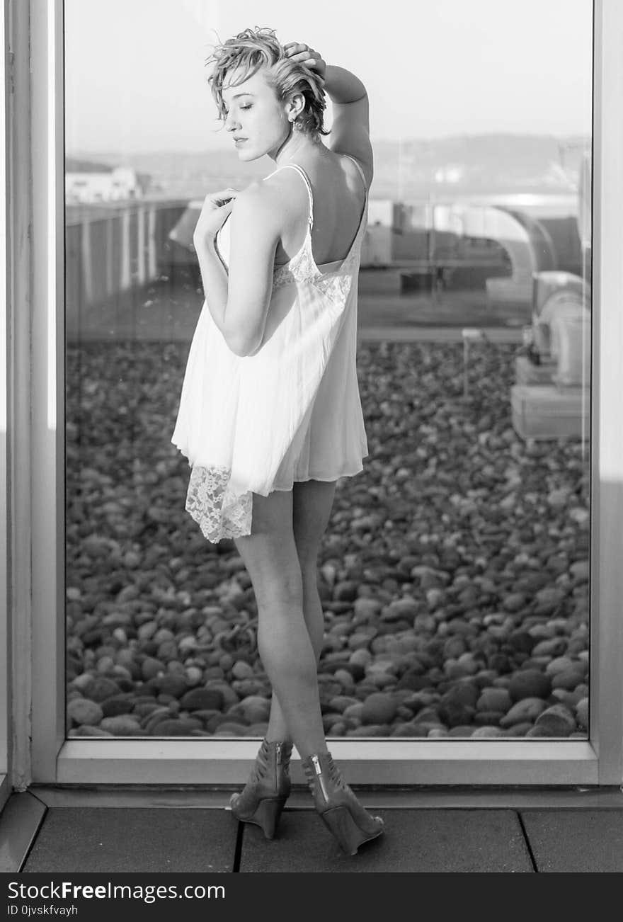 Greyscale Photograph of Woman Wearing Spaghetti Strap Mini Dress While Standing