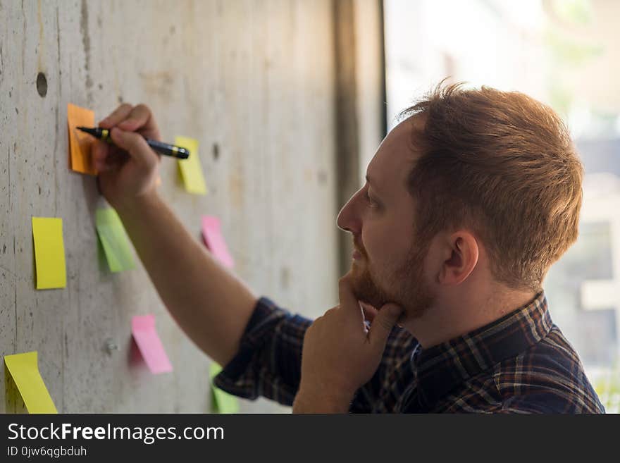 Creative businessman writing notes on paper in office