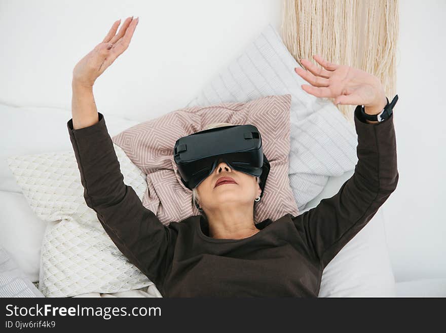 An elderly woman in virtual reality glasses. An elderly person using modern technology.