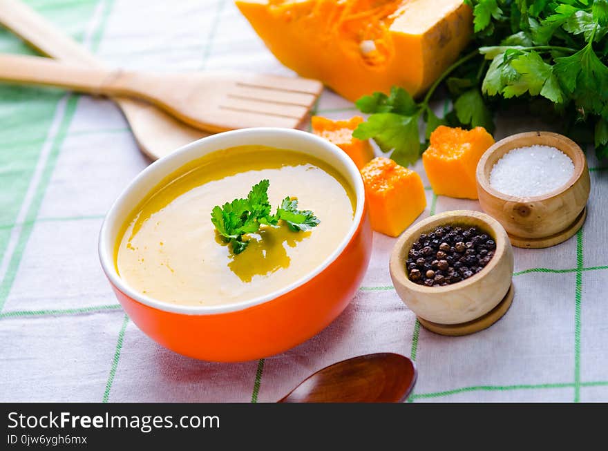 The pumpkin soup served on the table in bowl