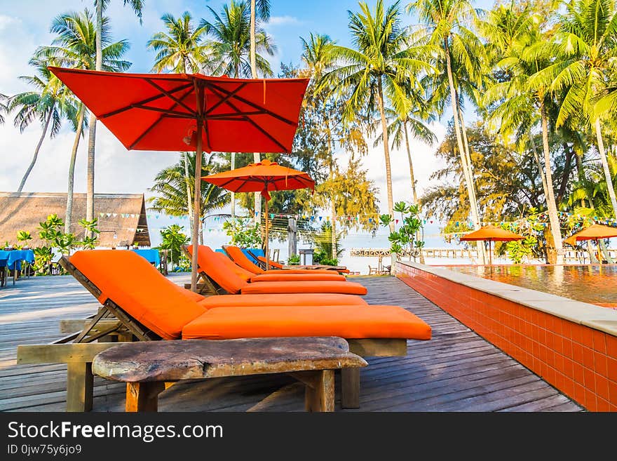 Umbrella and chair around swimming pool