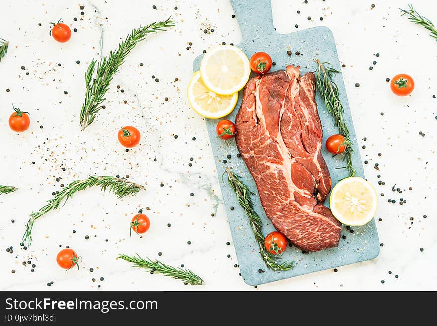 Raw beef meat on cutting board with vegetable and ingredient for cooking