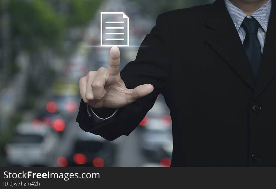 Businessman pressing document icon over blur of rush hour with cars and road, Business communication concept