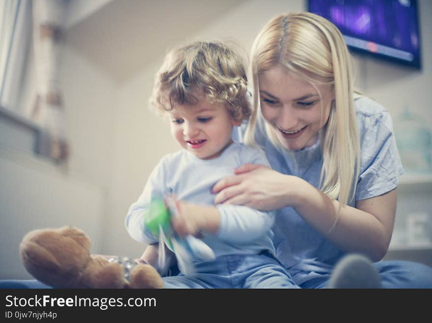 Young Mom playing with baby son in their living room.