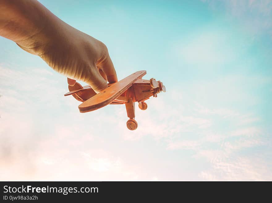 Toy airplane in hand - an inspiration of travel and dreams. Vintage color filter effect.