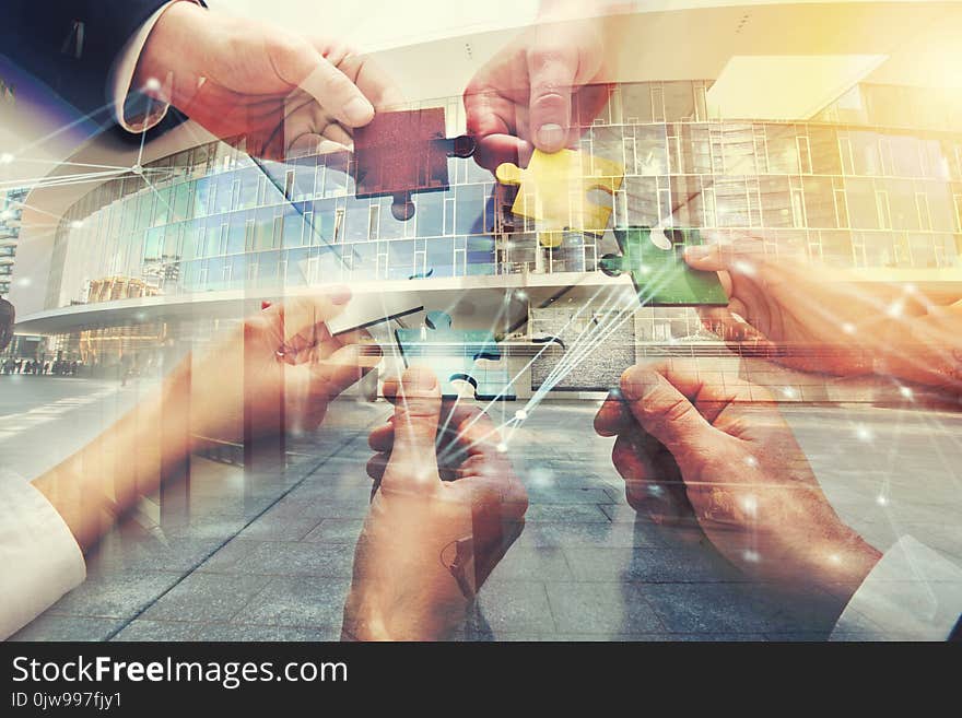 Businessmen working together to build a colored puzzle. Concept of teamwork, partnership, integration and startup. double exposure. Businessmen working together to build a colored puzzle. Concept of teamwork, partnership, integration and startup. double exposure