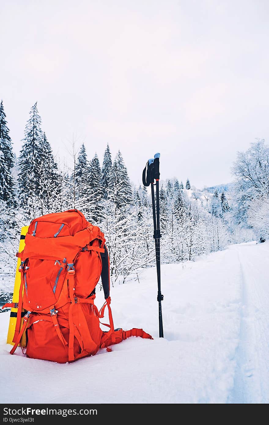 A red backpack in a winter hike against the backdrop of mountains and forests. A red backpack in a winter hike against the backdrop of mountains and forests.