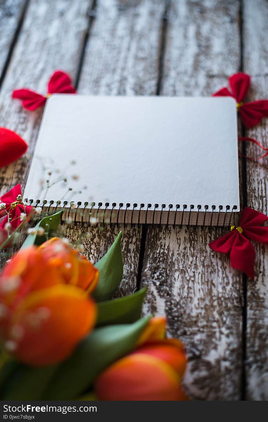 Tulips on a wooden old background and notebook