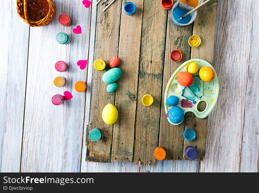 Easter eggs on a wooden background with paints