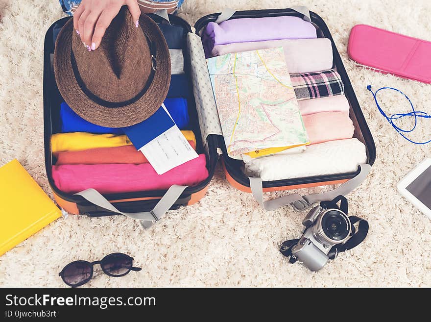 Open suitcase full of woman clothes, packed for travelling, close up.