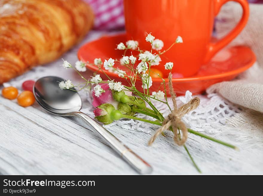 Cup of coffee and croissant with roses