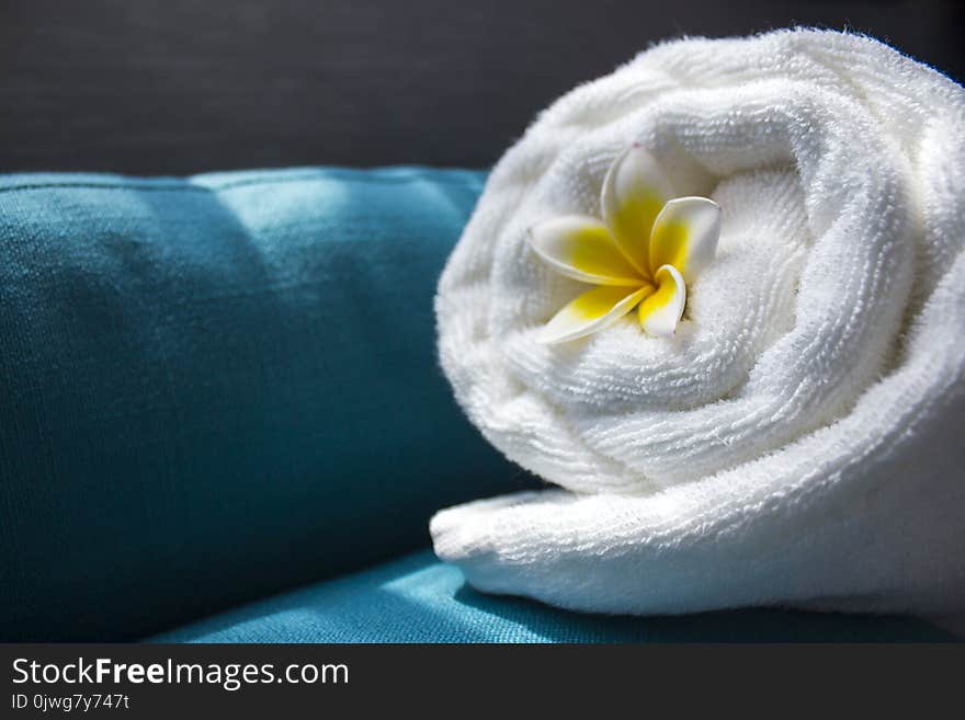 White towel and a flower of Frangipana on a dark background. The concept of SPA. Copy space 1