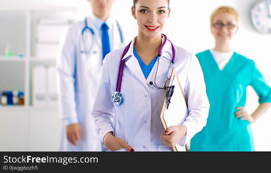 Woman doctor standing with folder at hospital .