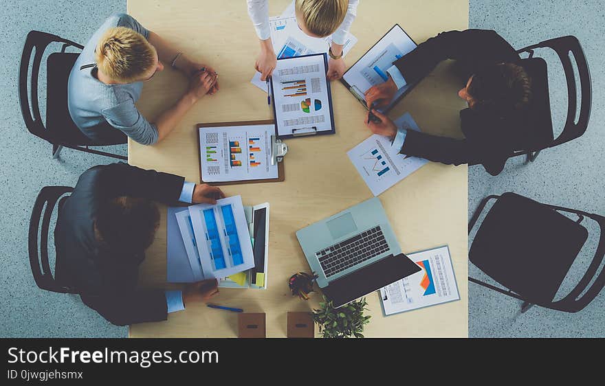 Business People Sitting And Discussing At Business Meeting, In Office