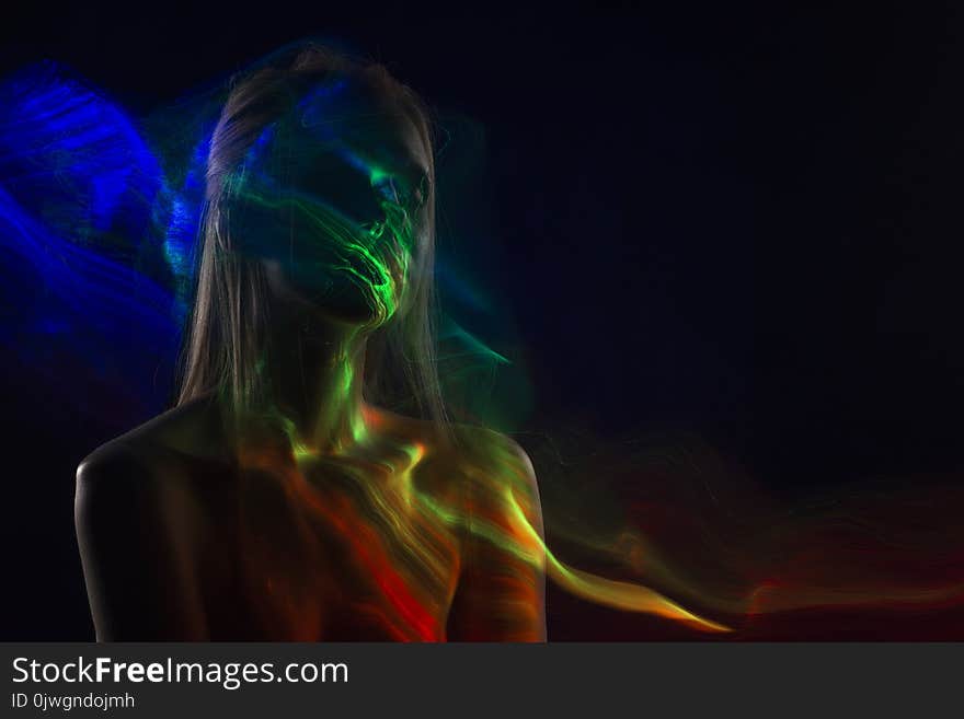 Conceptual avant-garde silhouette portrait of a beautiful blonde girl covered with multicolored lines applied by a lightbrush. Art photo.Copy space. Advertising, fashion and commercial Design