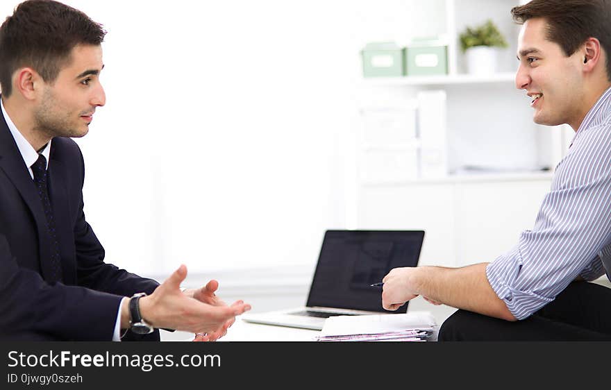 Business people sitting and discussing at business meeting, in office