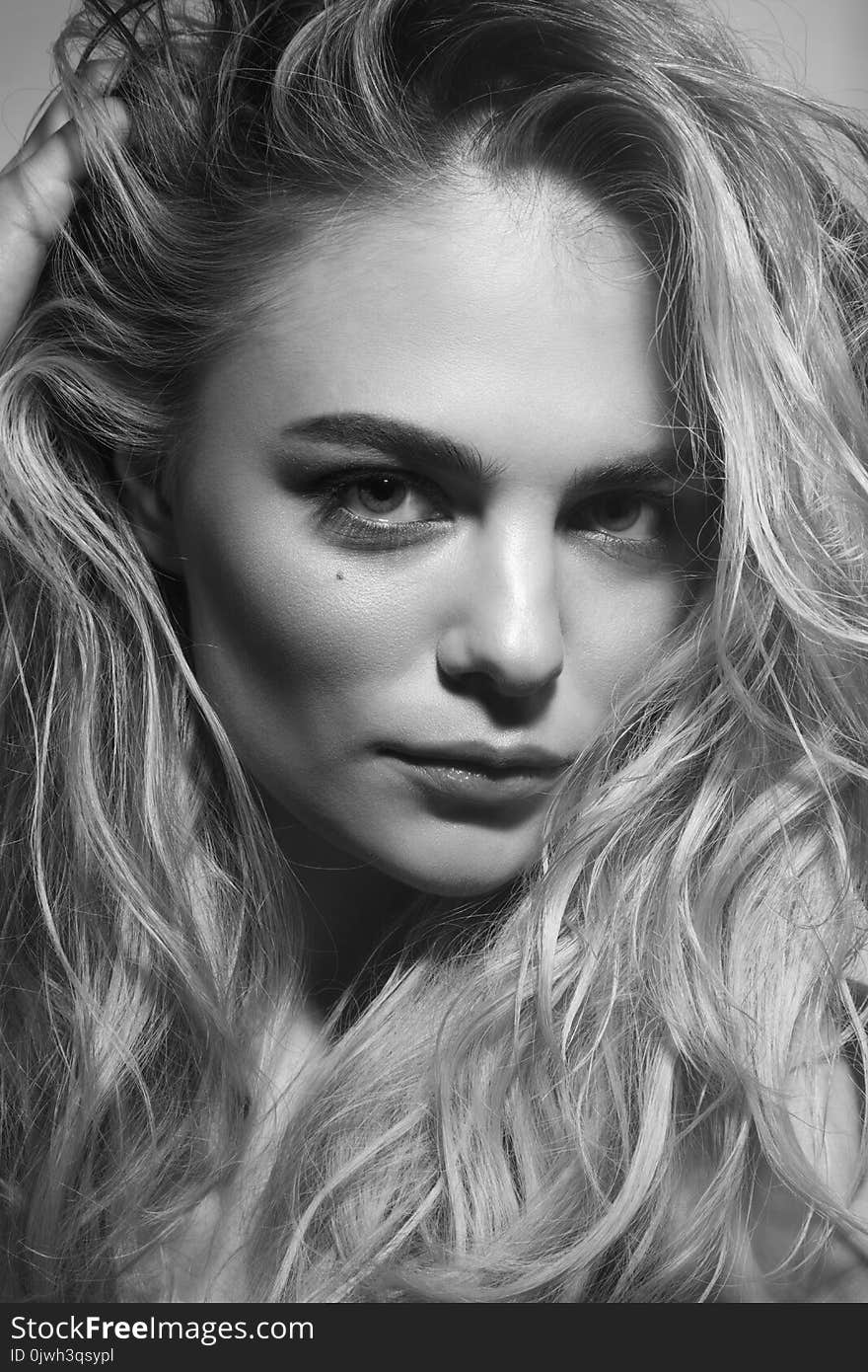 Black and white portrait of young beautiful woman with messy cur