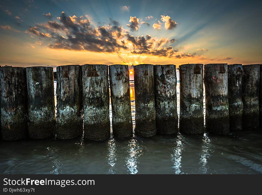 Sunset on beach with a wooden breakwater in Leba, Baltic Sea, Po