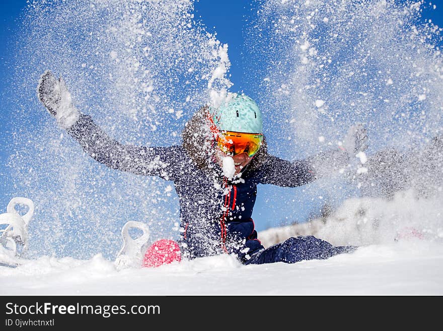 Picture of athlete woman sitting in snowdrift , throws snow in winter