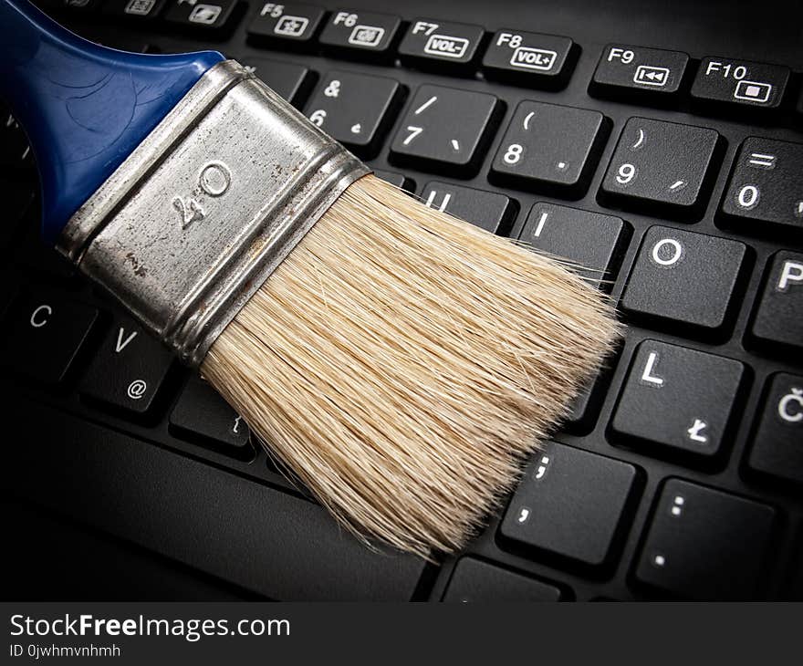 The brush cleans the computer keyboard as a concept of maintaining digital data. The brush cleans the computer keyboard as a concept of maintaining digital data.