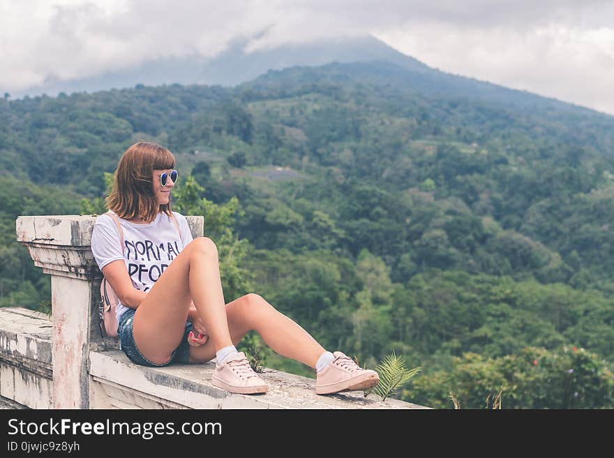 Woman in White Shirt and Blue Denim Short Shorts Sitting