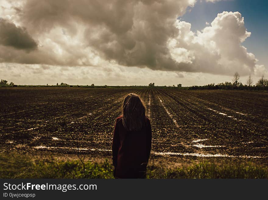 Women&#x27;s Red Sweat Shirt Standing in the Middle of the Field