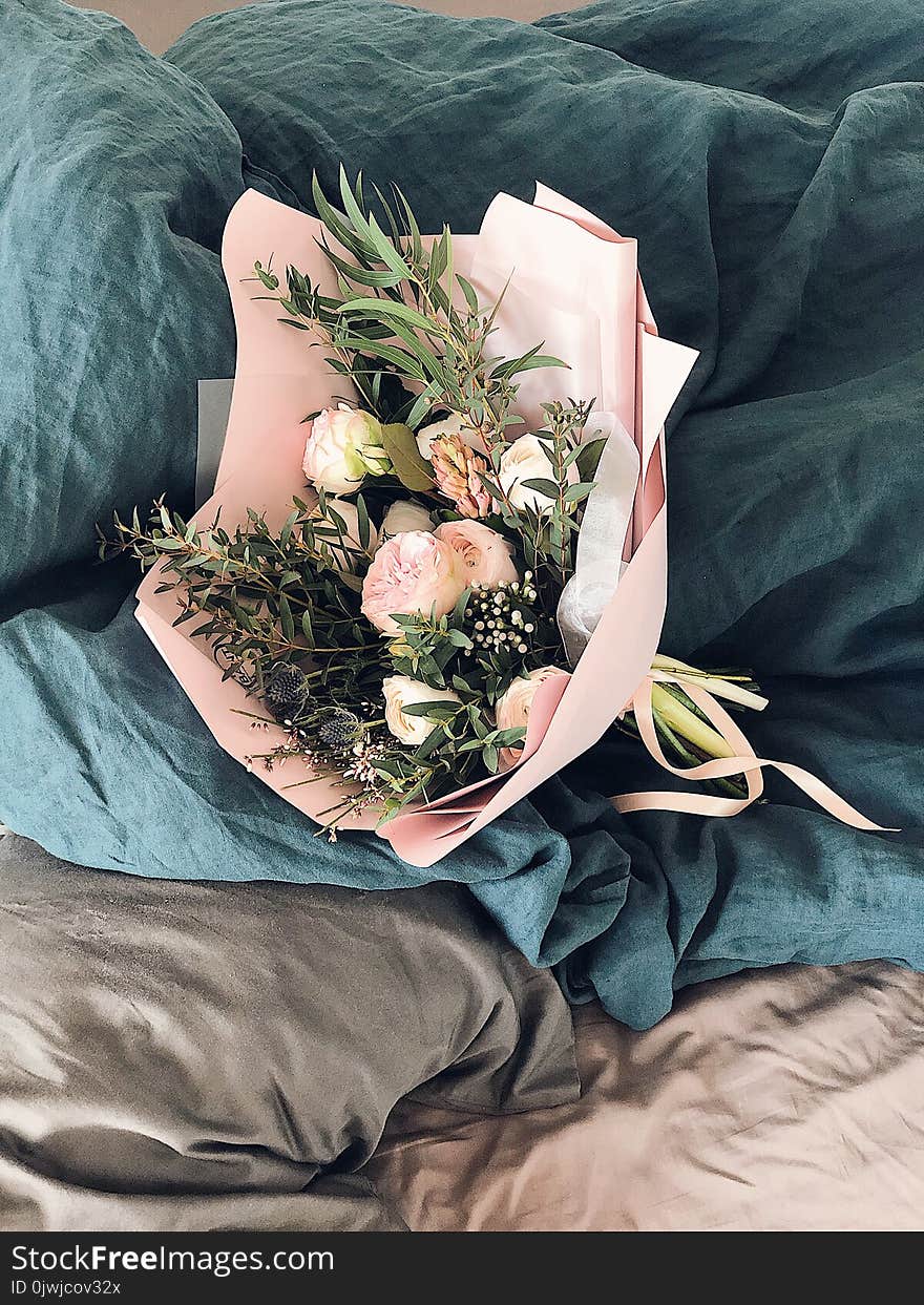 Pink and Green Flower Bouquet on Bed Sheet