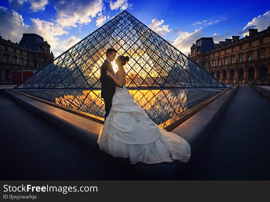 Photography of Man and Woman at the Lourve Museum during Sunset