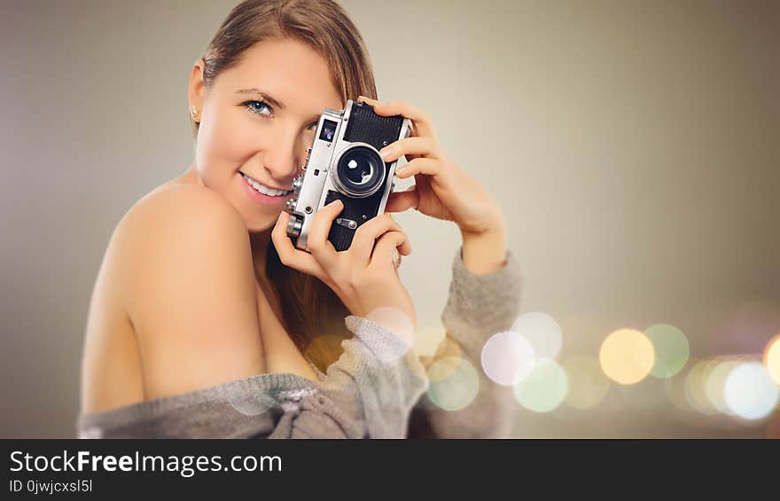 Woman With Gray Dress Holding Camera