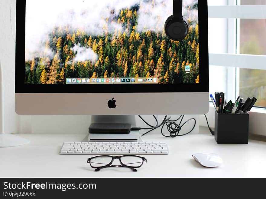 Turned on Silver Imac With Might Mouse and Keyboard