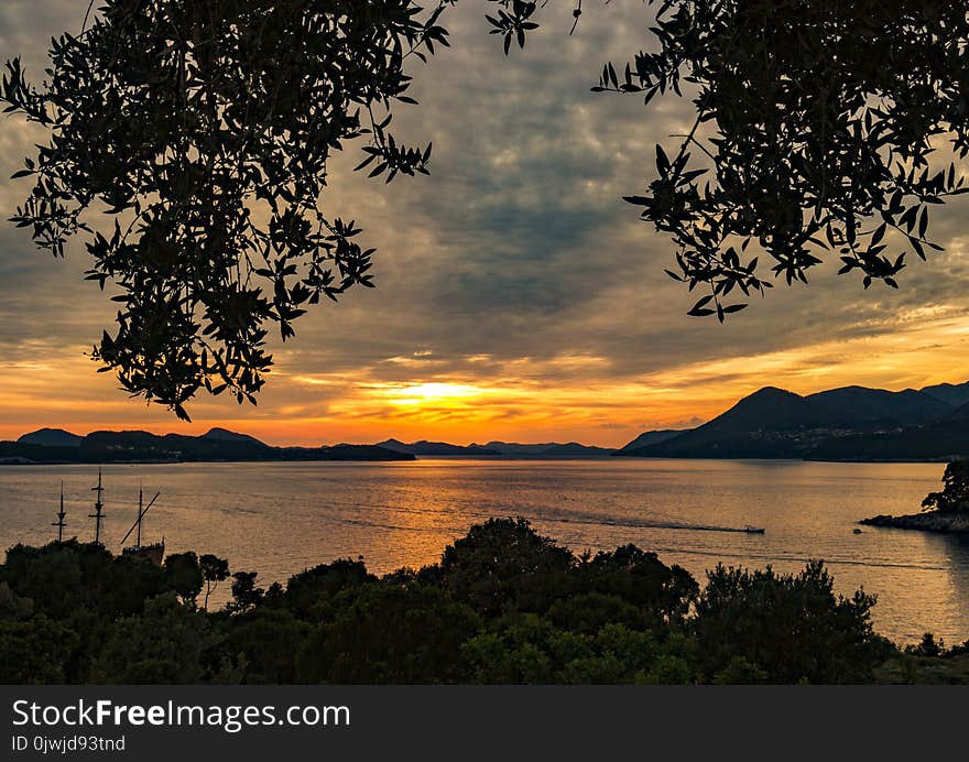 Silhouette of Mountain Near Body of Water during Sunset