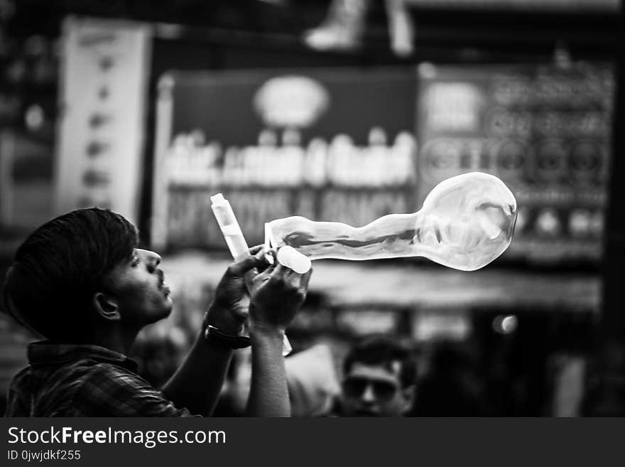 Man Playing Bubbles Grayscale Photo