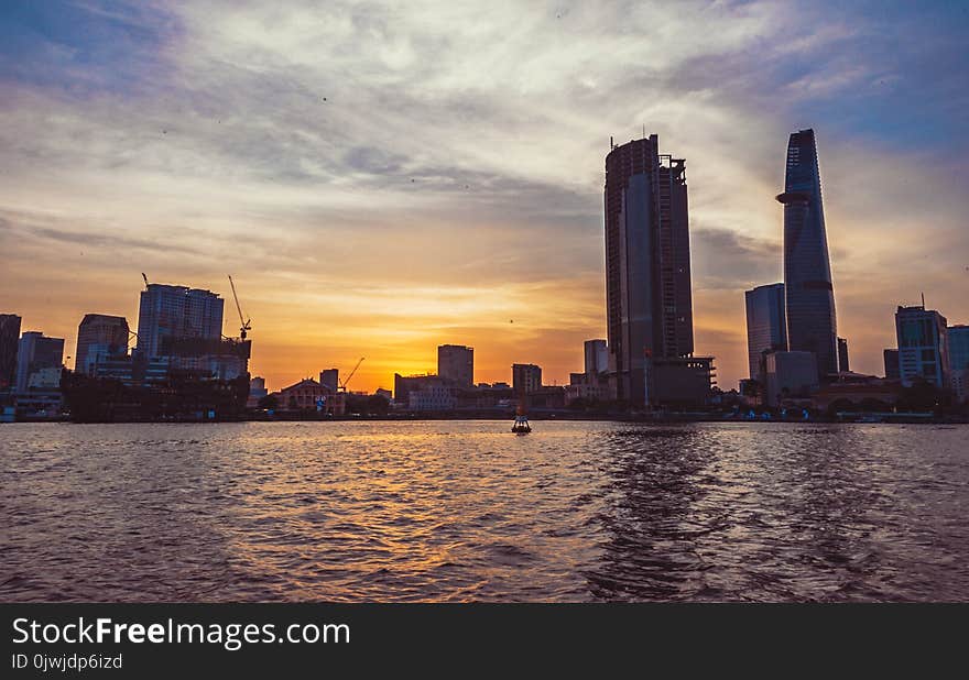 High-rise Building in Front of Body of Water during Sunset