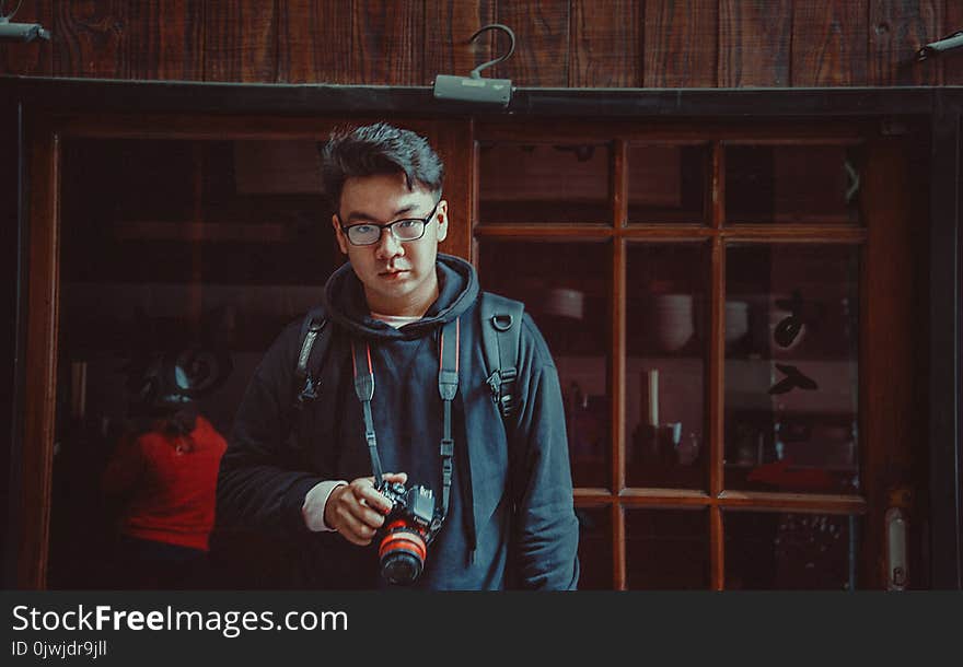 Man Wearing Jacket Holding Dslr Camera