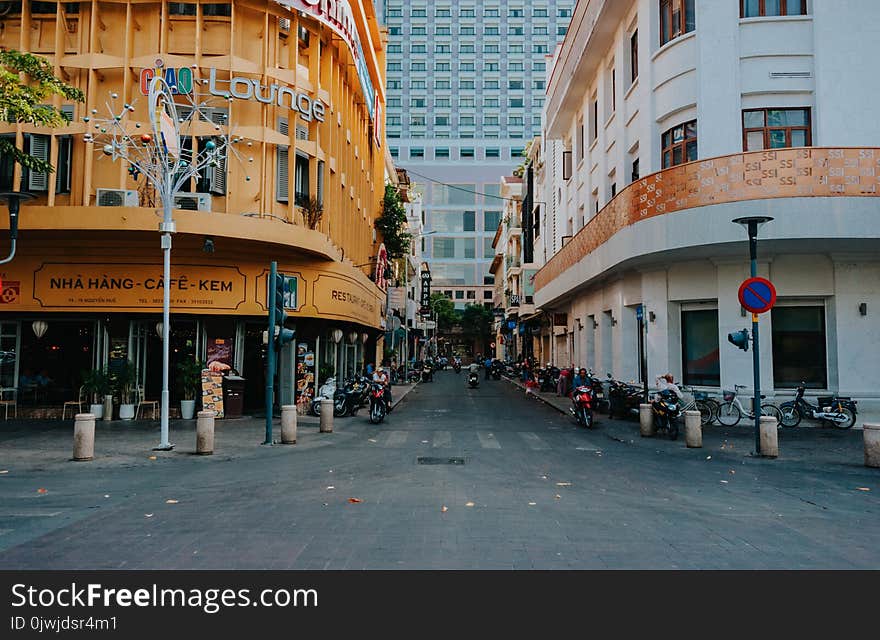 Gray Asphalt Street in Between Yellow and White Concrete Buildings at Daytime