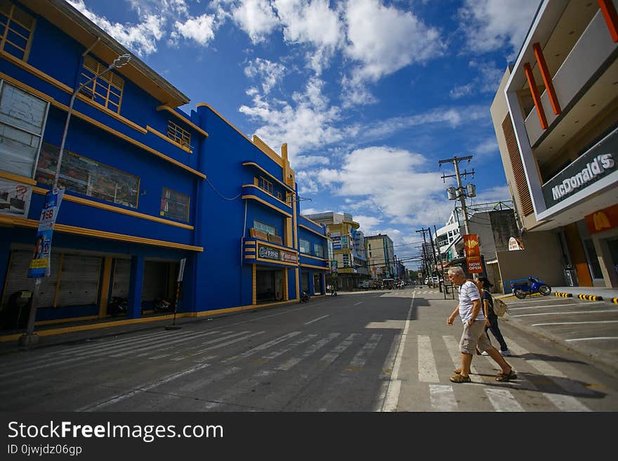 Man in White Top Crossing on Pedestrian