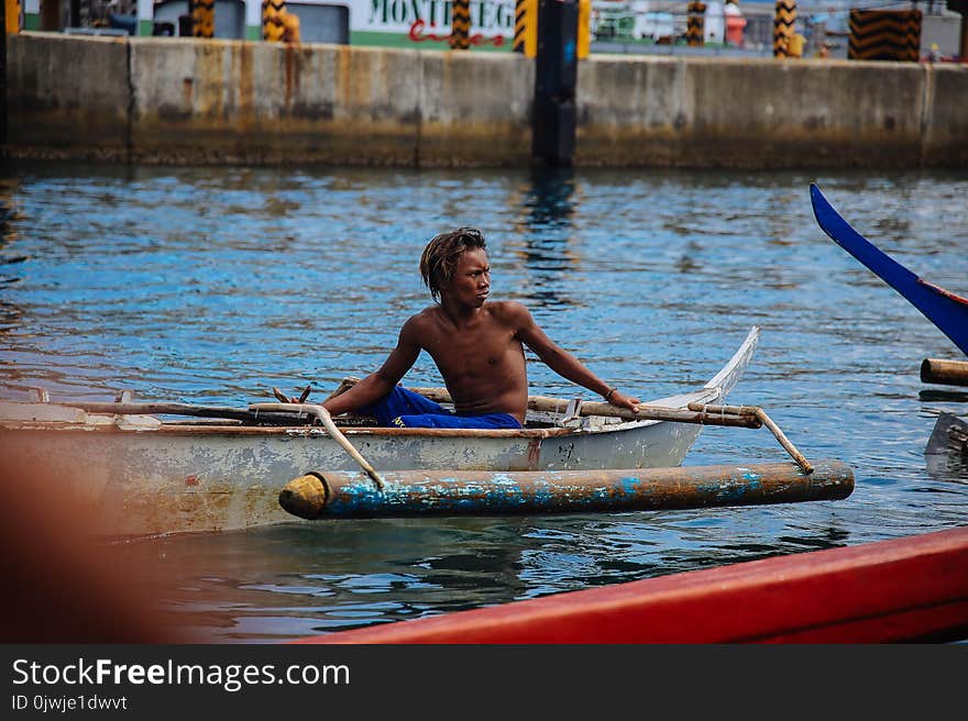 Man in Blue Shorts on Gray Boat