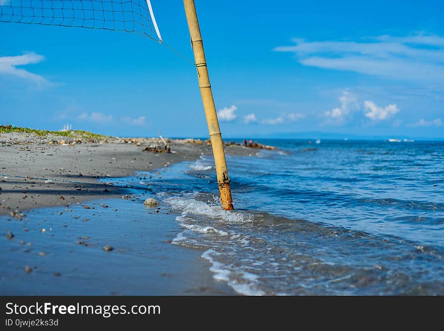 Closeup Photo of Brown Bamboo Beach Volleyball Post Near Shoreline