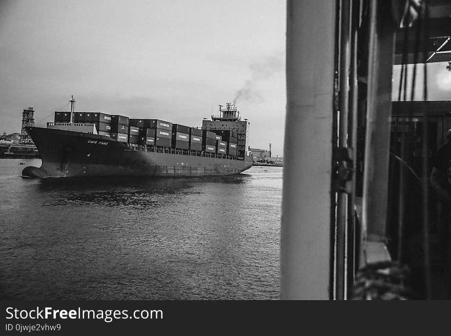 Greyscale Photo of Cargo Ship on Ocean