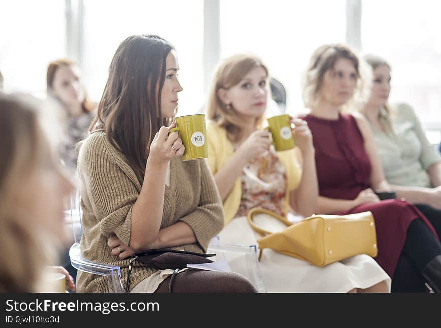 Woman Wearing Brown Corduroy Coat Holding Mug While Sitting on Chair