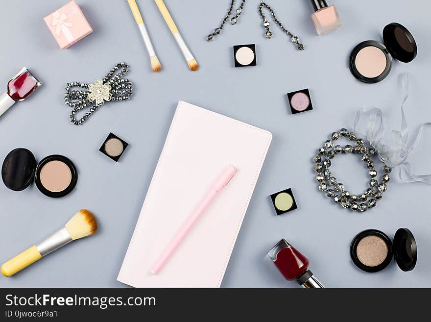 Beauty, fashion blogger concept. Fashion accessories, note book and cosmetics on grey background flat lay. Top view