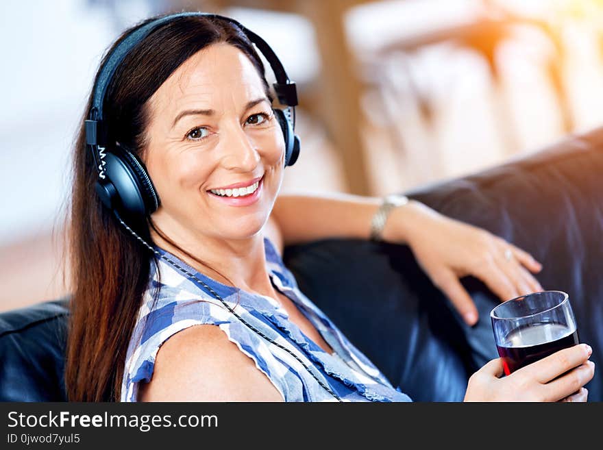 Happy smiling woman relaxing and listening to music with headphones