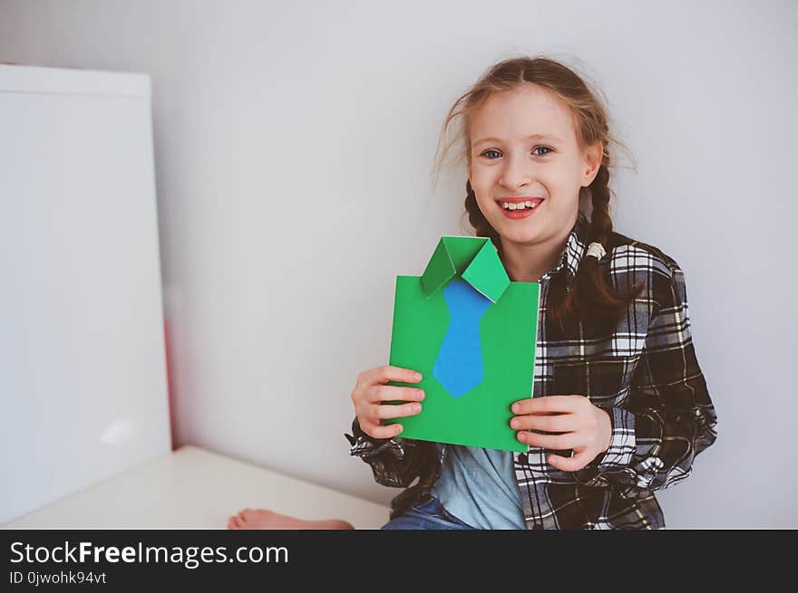 Happy child girl making greeting card for gift for Fathers Day.