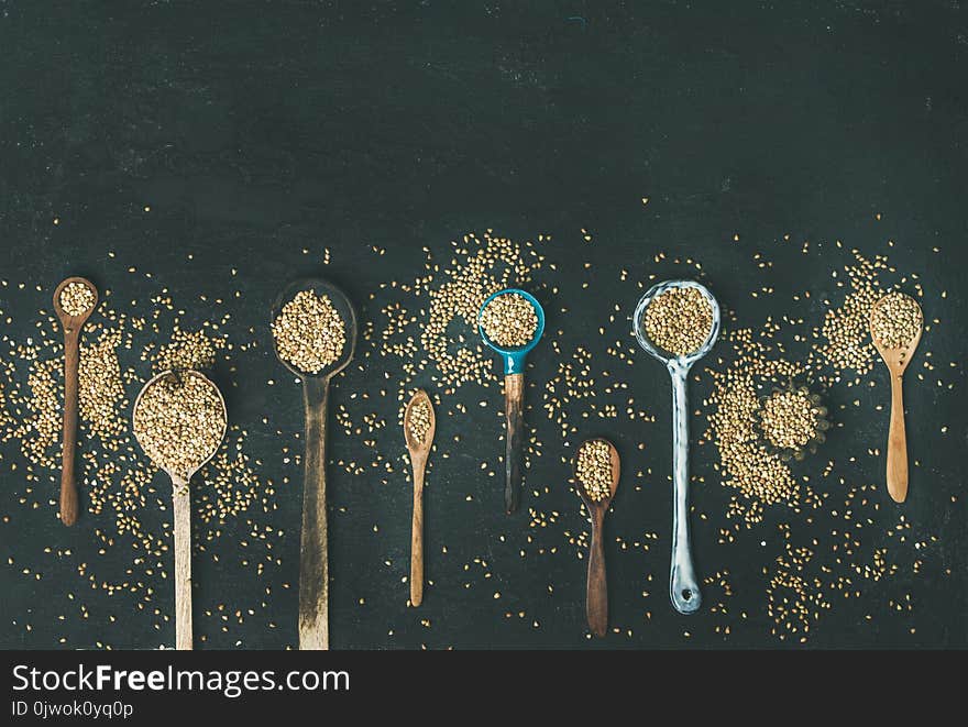 Various Kitchen Spoons Full Of Green Buckwheat Grains, Copy Space