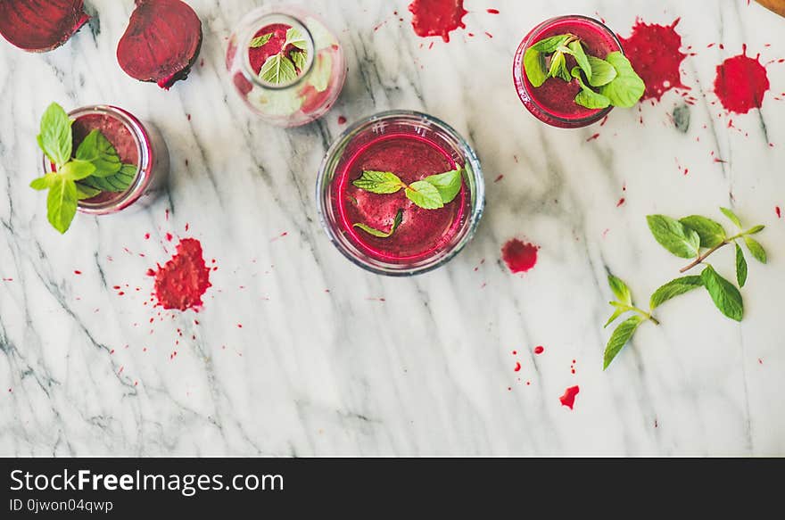 Fresh morning beetroot smoothie or juice in glasses with mint leaves over grey marble background, copy space, top view. Healthy vegan, vegetarian breakfast, alcaline diet, weight loss food concept. Fresh morning beetroot smoothie or juice in glasses with mint leaves over grey marble background, copy space, top view. Healthy vegan, vegetarian breakfast, alcaline diet, weight loss food concept