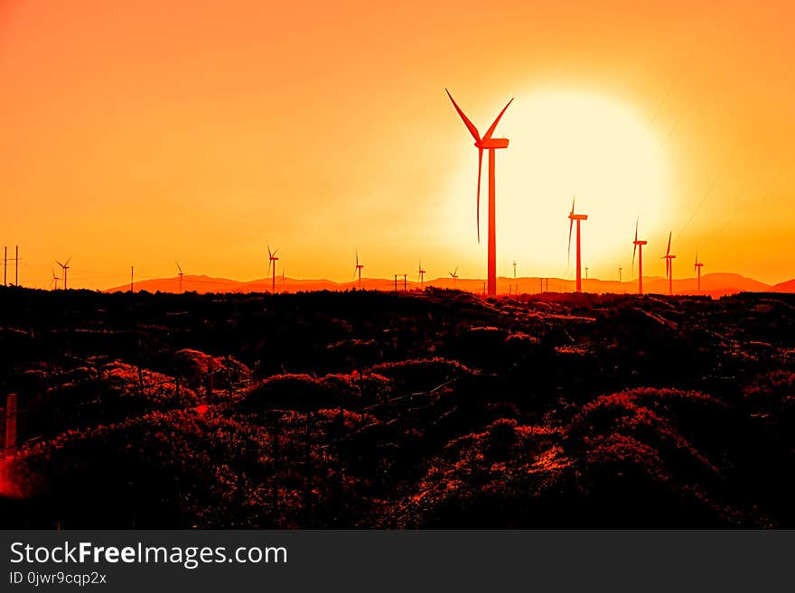 Wind turbines at orange sunrise